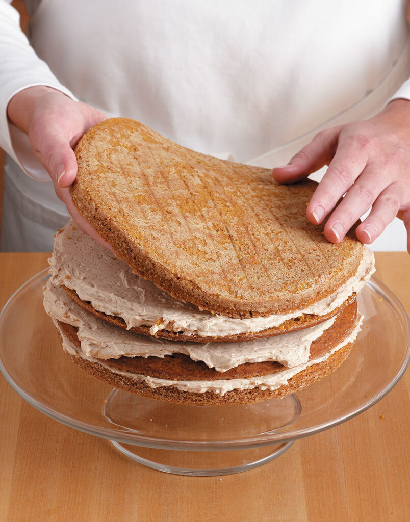 image of assemble cake layers and applying  cream to the black forest cake